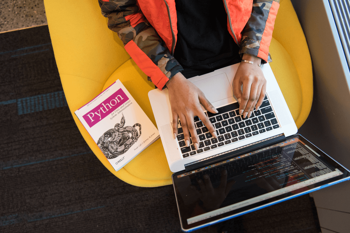 Um homem usando um notebook em cima de uma mesa amarela