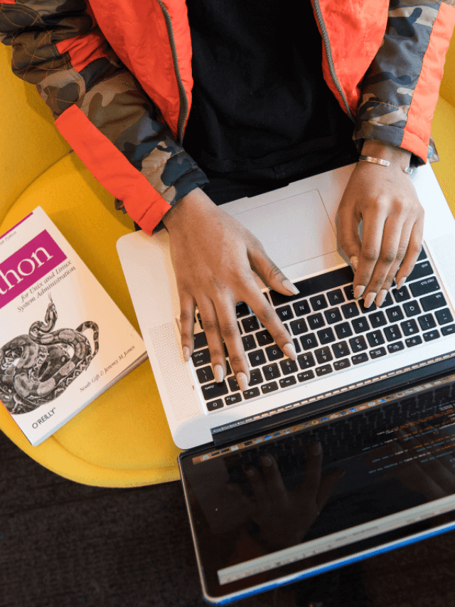 Um homem usando um notebook em cima de uma mesa amarela