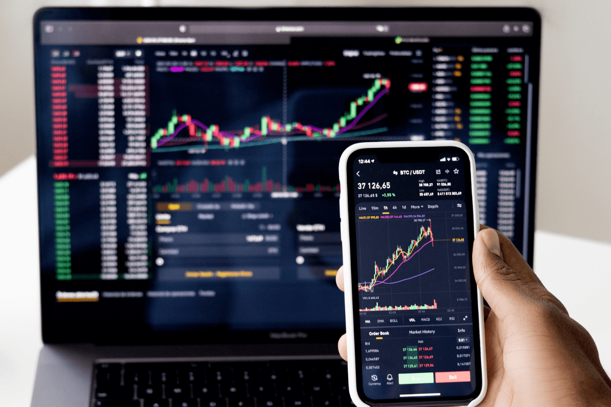 índices da bolsa de valores em uma tela de celular e de notebook